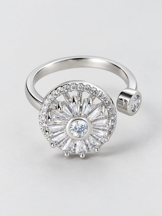 Anillo giratorio plateado con diseño de rayos de sol